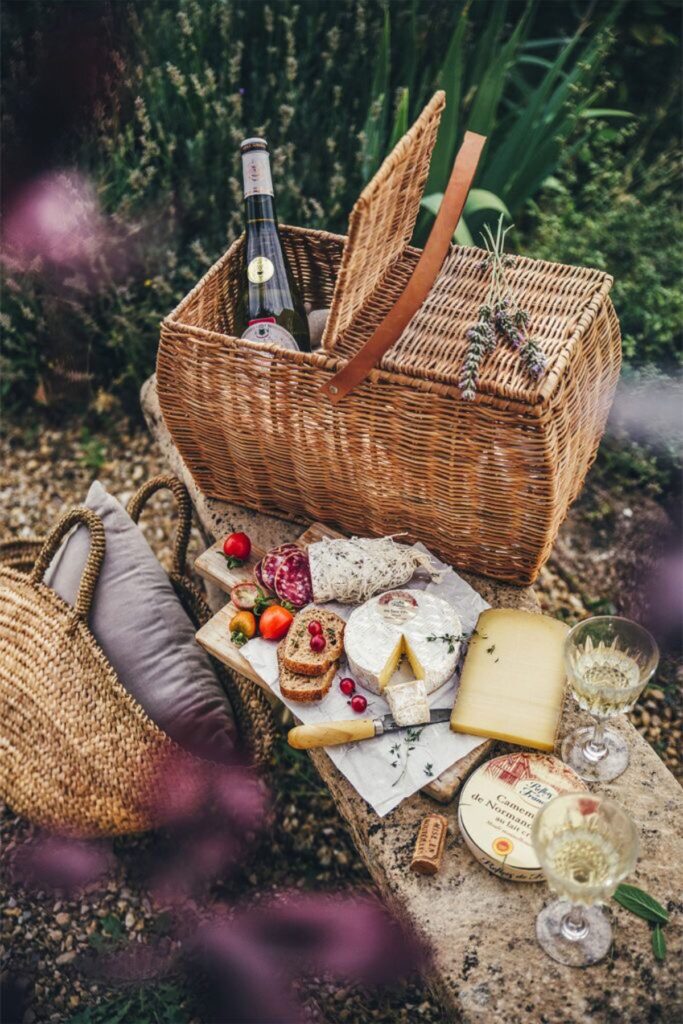 Coș de picnic pregătit cu fructe, brânzeturi și vin