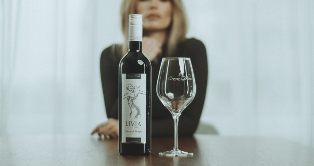 Cât rezistă vinul după deschidere? sticla de vin Livia cu screw-cap alături de un pahar pentru vin