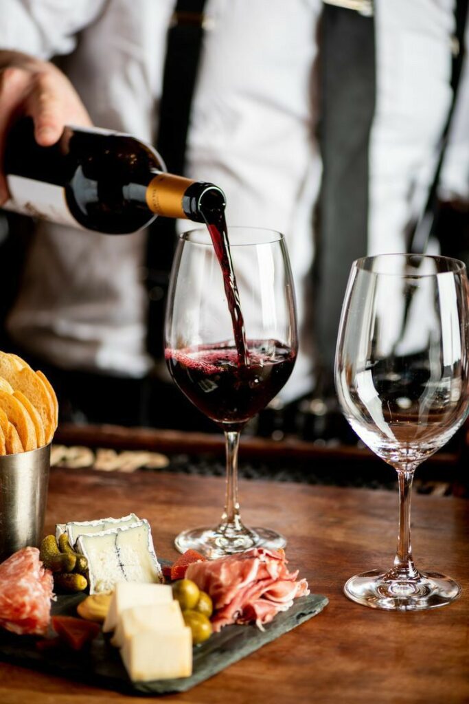 Cât vin cumperi pentru un eveniment? Ghid complet pentru nunți, petreceri și cine festive pahar de vin roșu in asociere cu mâncare